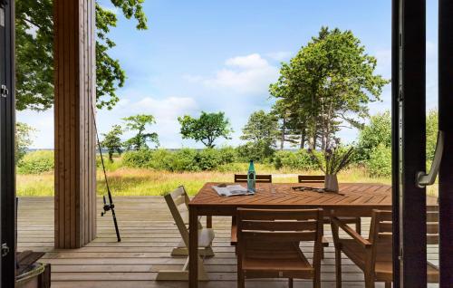 a wooden table and chairs on a wooden deck at 3 Bedroom Pet Friendly Home In Glesborg in Glesborg