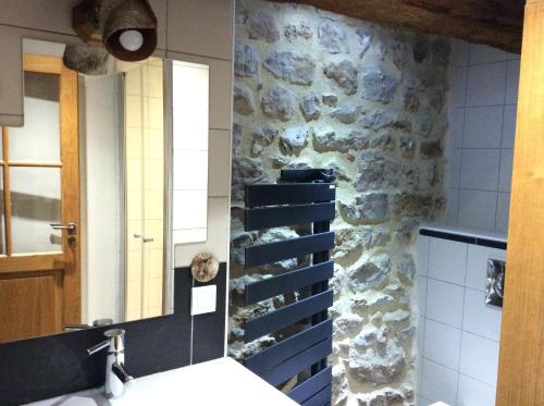 a bathroom with a sink and a stone wall at Domaine de Noyer in Saint-Christophe-en-Brionnais