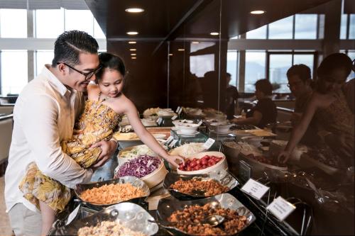 een man en een vrouw die voor een buffet staan bij Altara Suites Da Nang by AHG in Da Nang