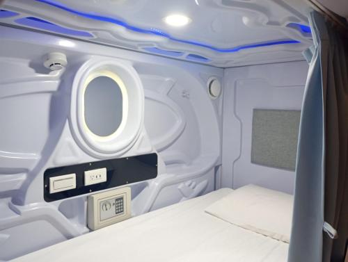 a small room with a bed in an airplane at SleepBox Hostel in Taipei