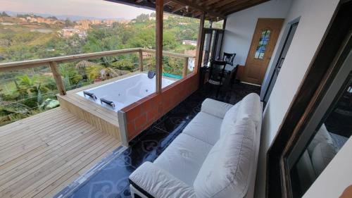 a balcony with a bath tub on a deck at EDYMA Cabaña con JACUZZI in Guatapé