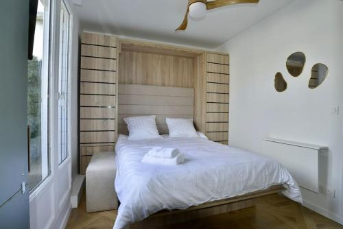 une chambre avec un lit blanc et une fenêtre dans l'établissement My Tiny House Paris, à Paris