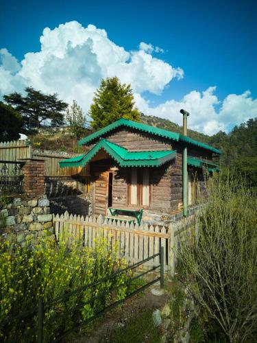 a wooden house with a fence in front of it at Seegreen Lodges in Mussoorie