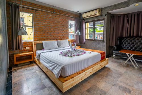 a bedroom with a bed and a brick wall at UNOTEL Karon Beach in Karon Beach
