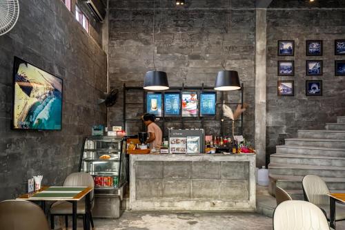 una persona parada en un mostrador en un restaurante en UNOTEL Karon Beach, en Karon Beach