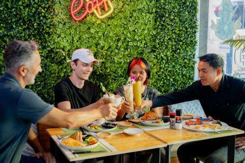 Un grupo de personas sentadas alrededor de una mesa comiendo comida en UNOTEL Karon Beach, en Karon Beach