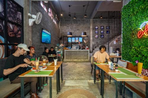 un grupo de personas sentadas en mesas en un restaurante en UNOTEL Karon Beach, en Karon Beach