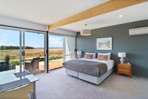 a bedroom with a bed and a large window at Lawsons Retreat in St Helens