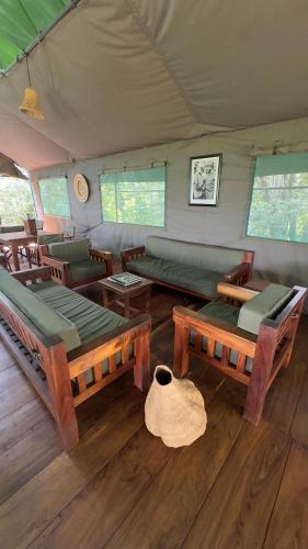 a living room with couches and tables in a tent at Hemingway's Luxury Tented Camp in Paraa