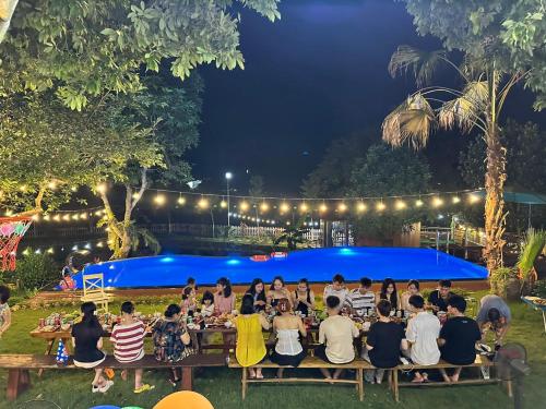 a group of people sitting at a table at night at 6Senses Garden Homestay in Hòa Bình