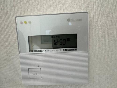 a digital clock on the side of a wall at Js House in Yokohama