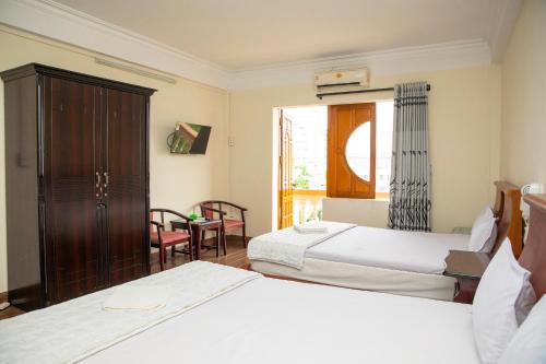 Kiều SơnにあるNgọc Hà Hotel 1のベッドが2つと窓があるホテルの部屋