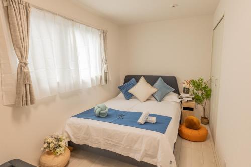 a bedroom with a bed with blue pillows and a window at 桜の川24 池袋駅 6分 10人3卧室别墅丨Ikebukuro 6 minutes 2-8 people in Tokyo
