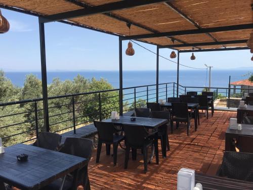 a restaurant with tables and chairs on a balcony at Assos Gardenya Butik Otel in Ayvacık