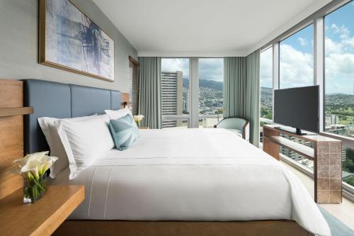 a bedroom with a large white bed and large windows at The Ritz-Carlton Residences, Waikiki Beach Hotel in Honolulu
