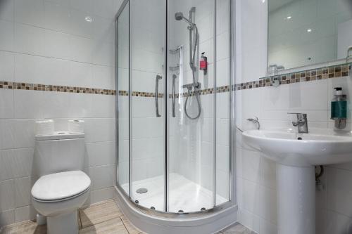 uma casa de banho com um chuveiro, um WC e um lavatório. em The Babbacombe Hotel em Torquay