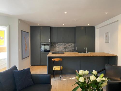 a kitchen with black cabinets and a kitchen island at Oldest bakery in Denmark 17 min from Airport 5 stars in Copenhagen