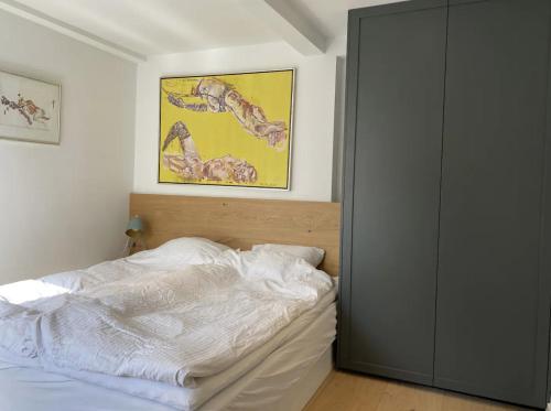 a bedroom with a bed and a painting on the wall at Oldest bakery in Denmark 17 min from Airport 5 stars in Copenhagen