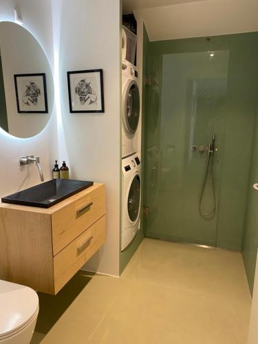 a bathroom with a sink and a washing machine at Oldest bakery in Denmark 17 min from Airport 5 stars in Copenhagen