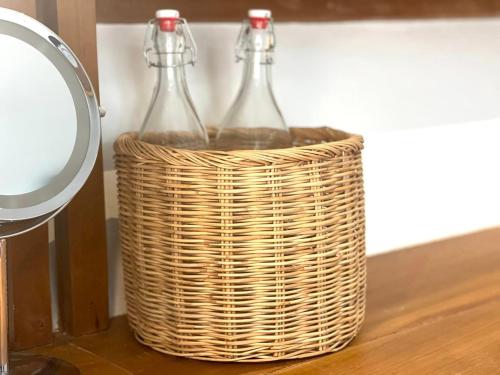 two glass bottles in a wicker basket on a table at The Safari Resort in Phumĭ Thlôk Yŭl