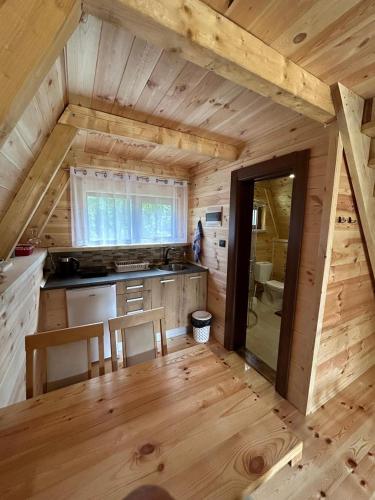 a kitchen in a log cabin with a wooden floor at Etno apartmani Komarnica in Šavnik