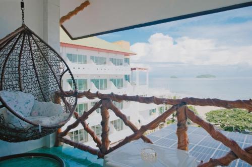 a balcony with a hammock and a view of the ocean at Mam Kaibae Hotel in Ko Chang