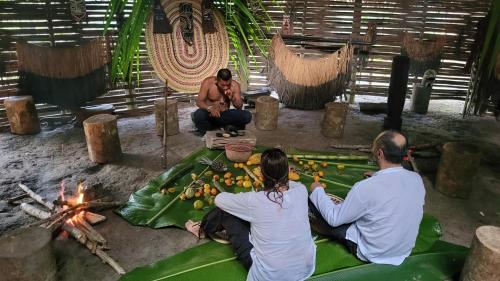 a group of three people sitting around a fire at Eco Hostel RENASE in Leticia