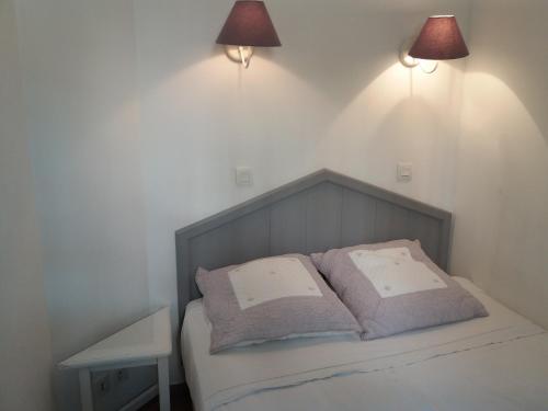 une chambre avec un lit avec deux oreillers dessus dans l'établissement Les Restanques de Saint Tropez, à Grimaud