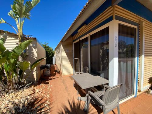 a patio with a table and chairs in front of a house at Osprey Holiday Village Unit 213 1 Bedroom in Exmouth