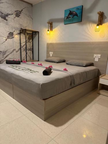 a bedroom with a large bed with pink flowers on it at Dive Villa Thoddoo in Thoddoo