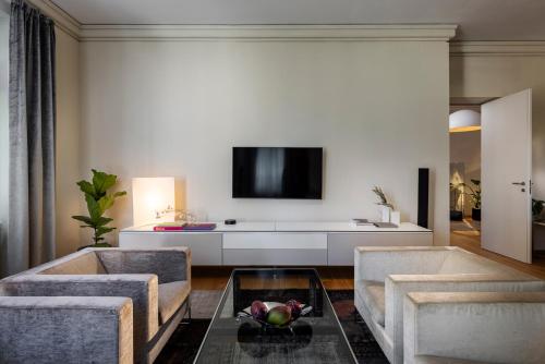 a living room with two chairs and a tv at The Nest by Juno Hotel Sofia in Sofia