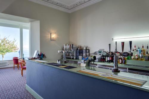 a bar in a room with a view of the ocean at The Babbacombe Hotel in Torquay