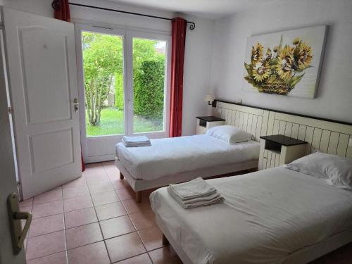 a room with two beds and a window and a door at Villa in Les Forges near Golf Course in Les Forges