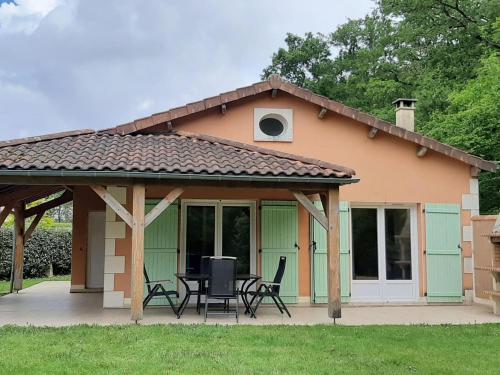 a house with a patio with a table and chairs at Villa in Les Forges with Golf and Pool in Les Forges