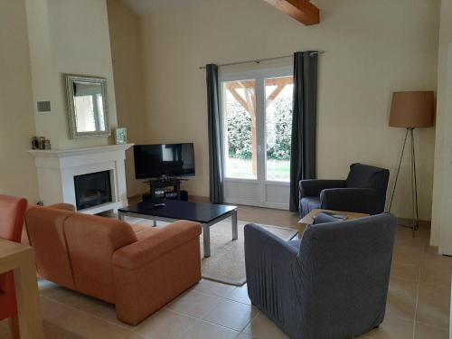 a living room with two chairs and a fireplace at Villa in Les Forges with Golf and Pool in Les Forges