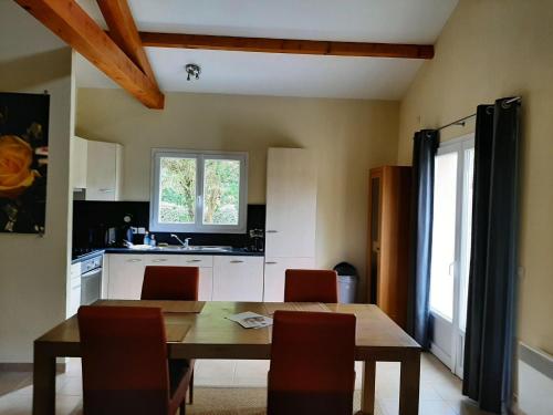 a kitchen with a wooden table and chairs in a room at Villa in Les Forges with Golf and Pool in Les Forges