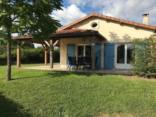a cottage with a porch and chairs in a yard at Villa in Les Forges with Golf & Pool Access in Les Forges