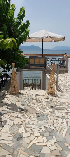 a patio with an umbrella and a table with chairs at Senia Holidays in Preveza