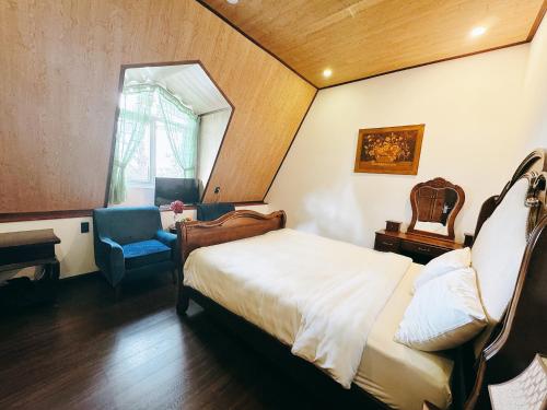 a bedroom with a bed and a chair and a window at TTR Joy Apart' Hotel in Da Lat