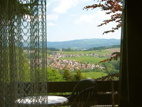 a table and chair on a balcony with a view at Ferienhaus Hajek in Freyung