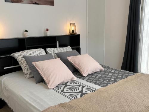 a bedroom with a bed with pink and grey pillows at Appartement calme,lumineux ,hyper centre TOURS in Tours