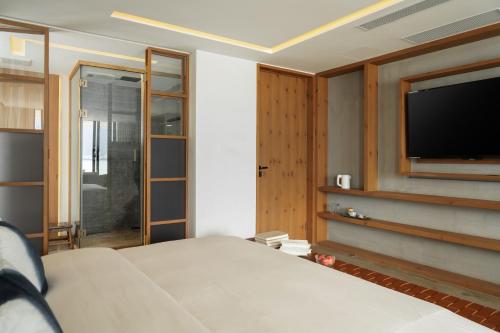 a bedroom with a bed and a flat screen tv at 慢境Slow Land半山海景花园酒店 in Dali