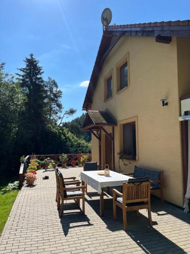 a patio with a table and chairs and a house at Chata Janet in Martin
