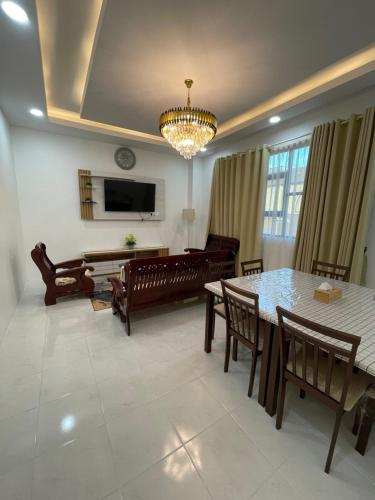 a living room with a table and chairs and a couch at MHI Homestay Bandar Baru Jelawat in Bachok