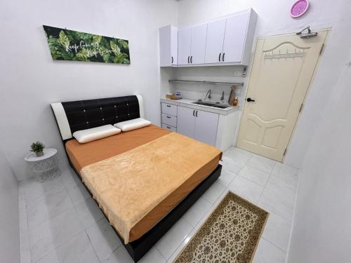 a small bedroom with a bed and a kitchen at MHI Homestay Bandar Baru Jelawat in Bachok