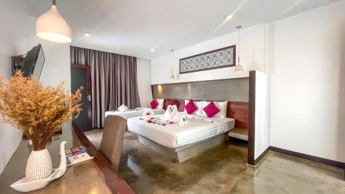 a bedroom with two beds with red pillows at The Calm Oasis in Siem Reap