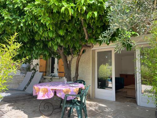 a table and chairs sitting under a tree at PierrAnge in Grillon