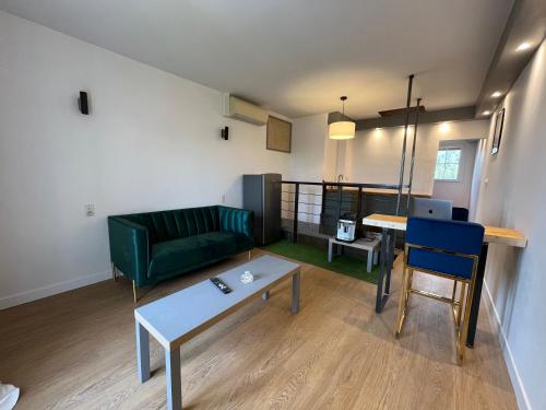 a living room with a green couch and a table at PierrAnge in Grillon