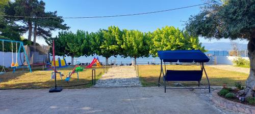 a park with a playground with chairs and trees at Senia Holidays in Preveza