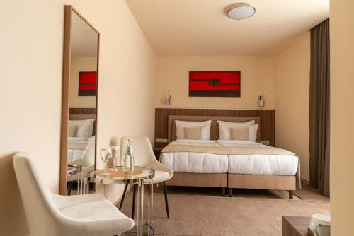 a hotel room with a bed and a table and chairs at PENSIUNEA GAMBRINUS **** in Miercurea-Ciuc